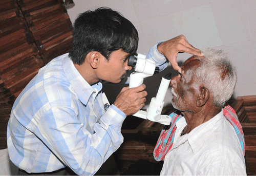 a young man using equipment to examine eye of older man