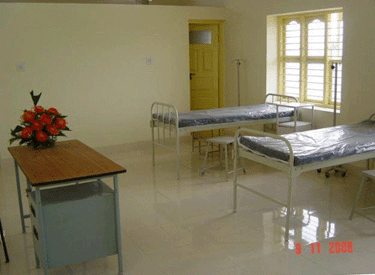 A hospital room with beds and a window